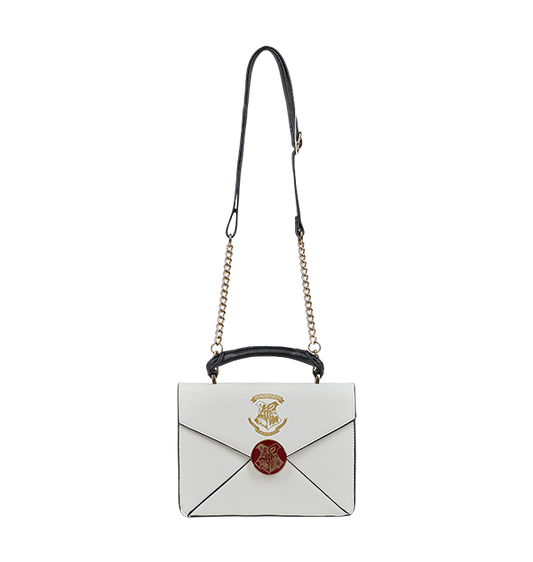 A cream-colored crossbody bag with an envelope design, featuring the Hogwarts school crest in metallic gold print, a metal burgundy clasp, and Harry Potter’s address printed in gold lettering.