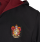 Close-up of a black hooded robe with a burgundy inner hood lining and an embroidered Gryffindor crest patch on the chest.