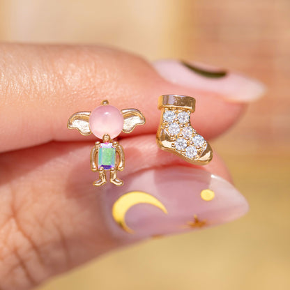 Two unique earrings held between fingers with a blurred background