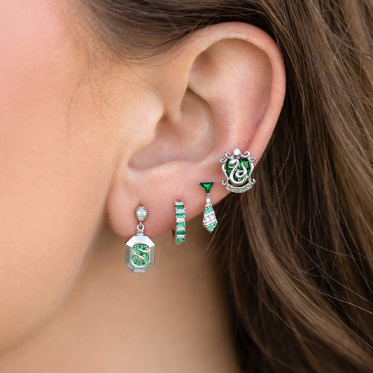 Close-up of an ear wearing green and silver Slytherin earrings