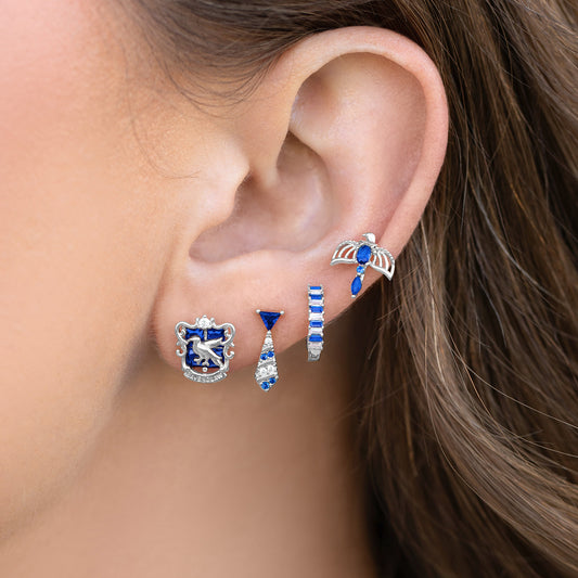 Close-up of an ear wearing multiple pairs of blue and silver Ravenclaw earrings.