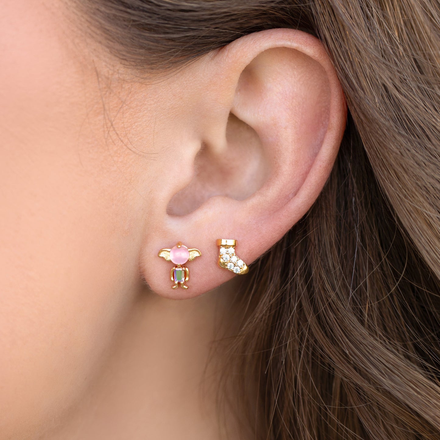 Close-up of an ear wearing colorful Dobby stud earrings