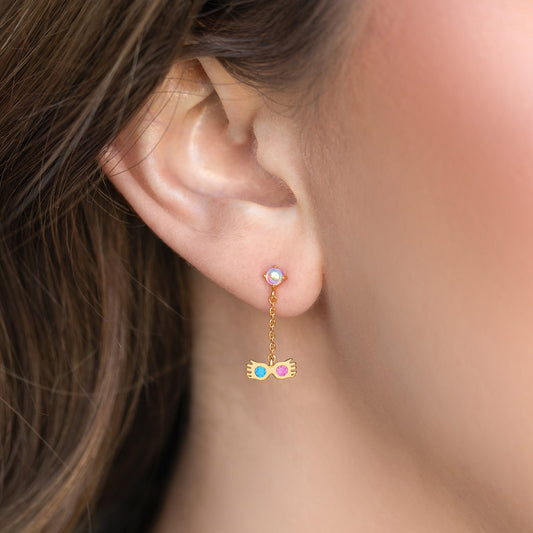 Close-up of an ear wearing a gold Luna Lovegood earring with colorful beads.