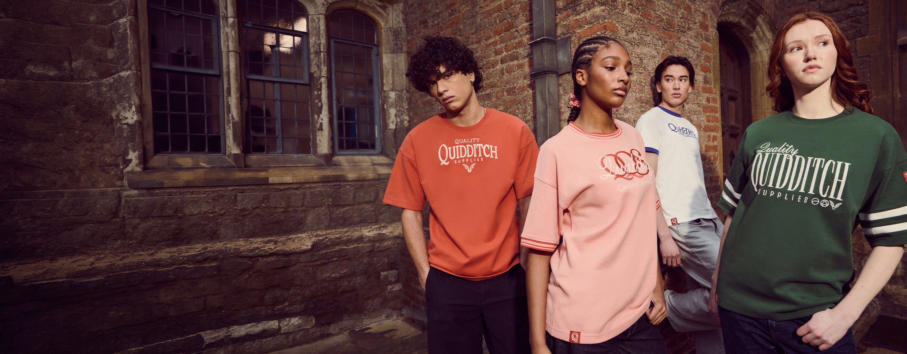 Four people wearing 'Quidditch' themed t-shirts in front of a brick building.