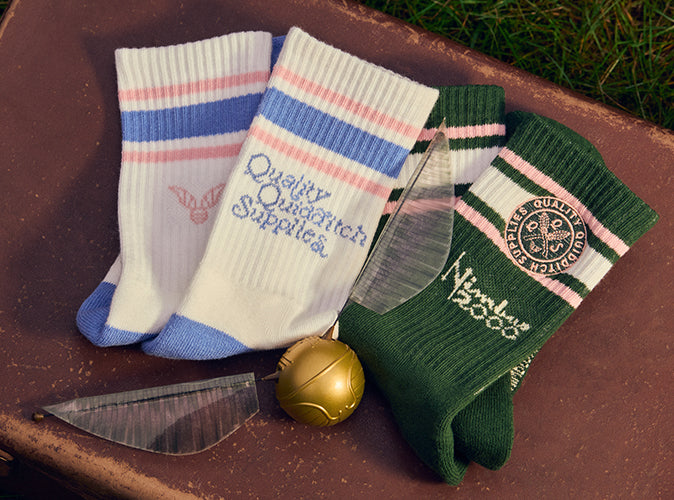 Two pairs of socks with visible Quidditch branding on a trunk surface.