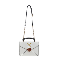 A cream-colored crossbody bag with an envelope design, featuring the Hogwarts school crest in metallic gold print, a metal burgundy clasp, and Harry Potter’s address printed in gold lettering.
